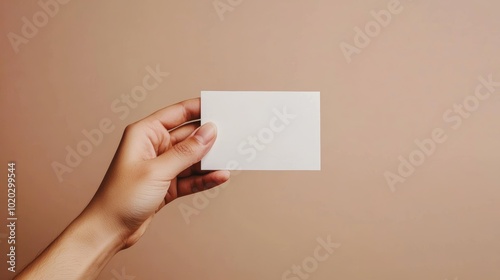 Hand with a plain white card in a vertical position, clean and minimalist composition, perfect for customizable templates, business branding, or ID visuals