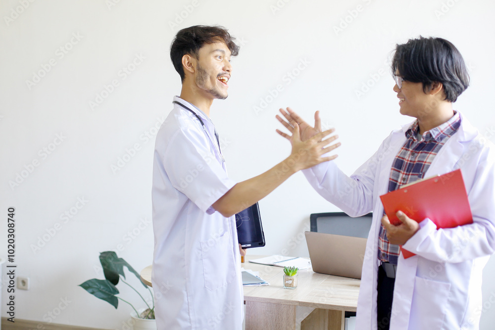 Fototapeta premium Two Asian Medical Students Shaking Hands At Hospital 