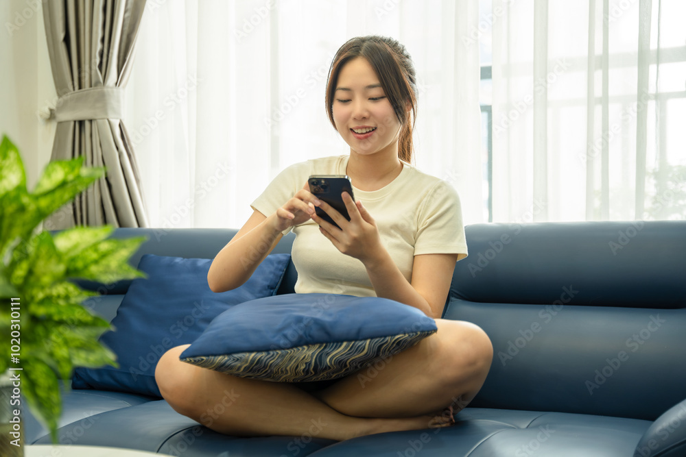 Image of young Asian girl using phone and relaxing at home Image of young Asian girl using phone and relaxing at home