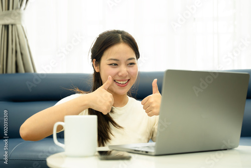 Portrait of young Asian girl using laptop and drink coffee , at home