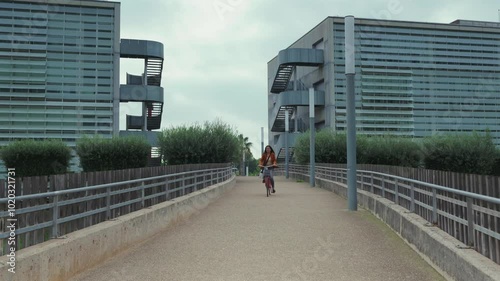 Wallpaper Mural A woman on a bicycle dressed in formal clothing passes between two buildings on her way to work. Torontodigital.ca