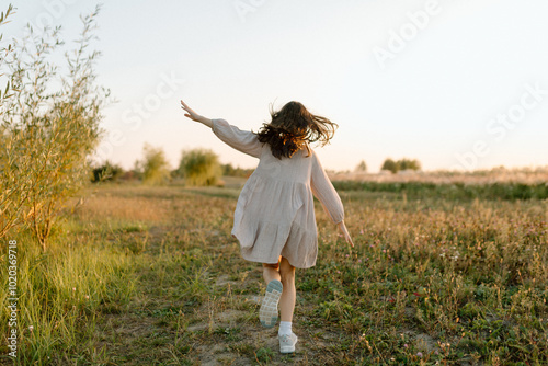 Little girl running through the field. Happy childhood concept. Cheerful child in meadow in sun. summer joy outdoors