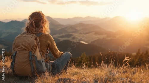 A hiker sitting on a grassy hilltop, looking out over rolling mountains under a golden sunset sky, depicting a sense of achievement and peaceful solitude.