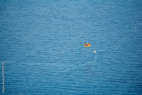 Vista dall'alto del mare e di una barca che pratica il parasail photo