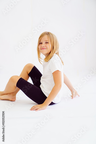 Cheerful teenage girl in white t-shirt and black breeches on white background