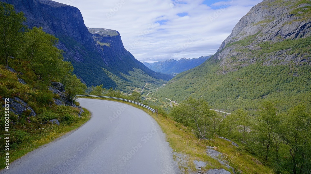 A winding road meanders through a stunning mountain landscape with lush green hills and impressive rocky cliffs under a bright sky A winding road meanders through a stunning mountain landscape with lush green hills and impressive rocky cliffs under a bright sky