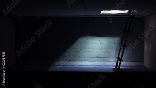Ray of light through trap door. kerosene lamp illuminates the dark basement