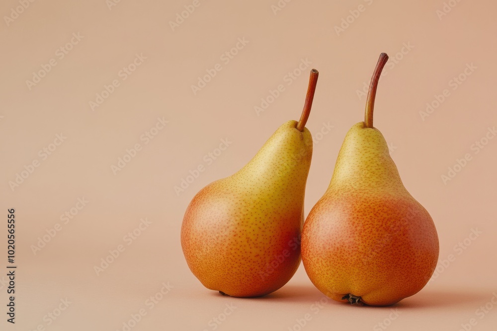 A pair of ripe pears nestled together against a soft pastel background A pair of ripe pears nestled together against a soft pastel background