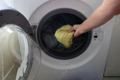 Woman's hand pick up clothes washing machine. Clean and healthy concept. High quality photo