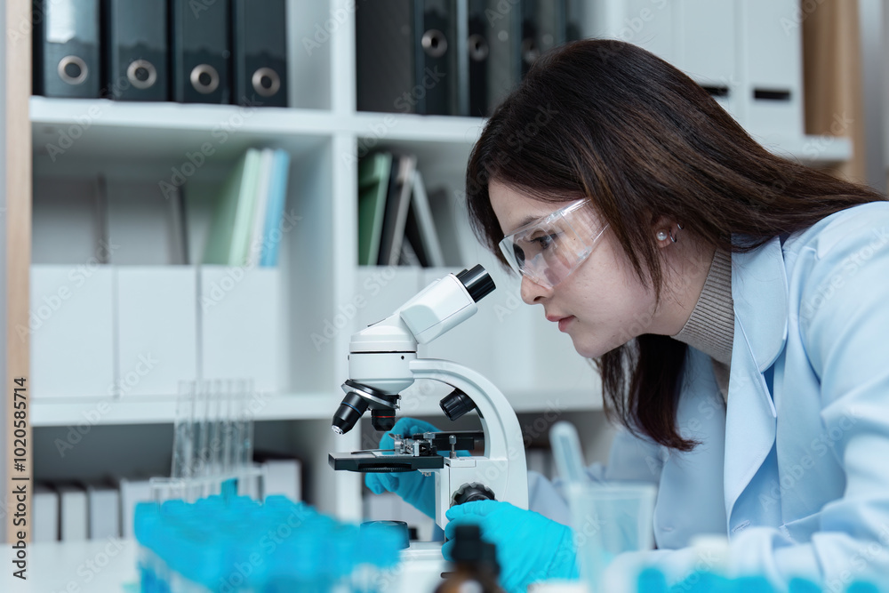 Scientist Conducting Research in Modern Laboratory with Microscope and Protective Gear Scientist Conducting Research in Modern Laboratory with Microscope and Protective Gear