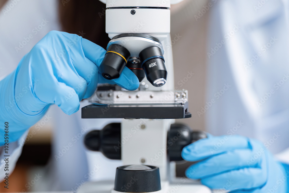 Scientist Using Microscope in Modern Laboratory with Blue Gloves for Scientific Research and Experimentation Scientist Using Microscope in Modern Laboratory with Blue Gloves for Scientific Research and Experimentation