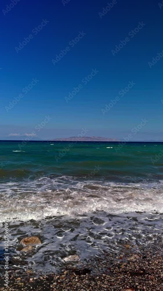 Serene Waves Gently Lapping the Shore on a Sunny Afternoon at the Beach Near a Distant Island Serene Waves Gently Lapping the Shore on a Sunny Afternoon at the Beach Near a Distant Island