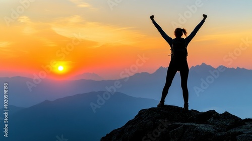 Silhouette of a Woman with Raised Arms Standing on a Mountaintop at Sunset