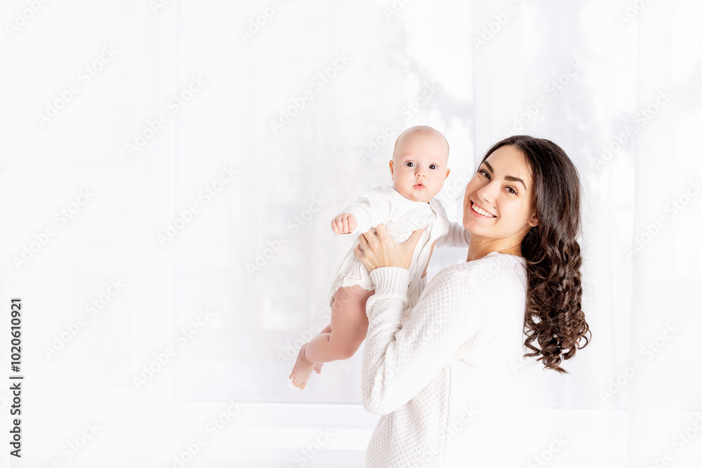 mom and baby, beautiful mother kissing newborn baby holding in his arms a home, the concept of happy loving family, lifestyle mom and baby, beautiful mother kissing newborn baby holding in his arms a home, the concept of happy loving family, lifestyle