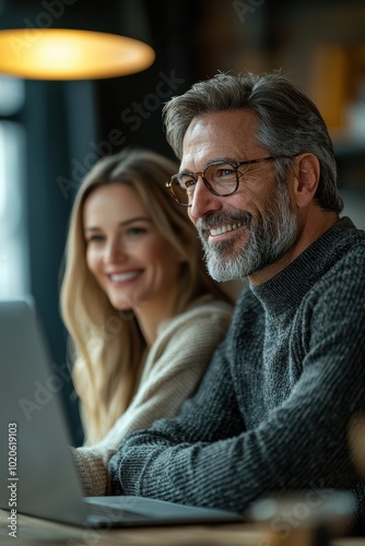 Wallpaper Mural Happy couple in their thirties sitting at home with laptop displaying photo collage and money, symbolizing financial success and a bright future together Torontodigital.ca