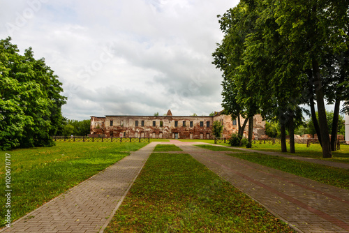 Ruins of the Bykhov castle made of red brick in the park with trees in the background and cloudy sky, Mogilev region, Belarus photo