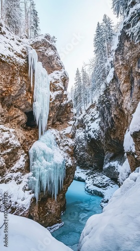 A breathtaking winter landscape with snowy cliffs, frozen waterfalls, and a serene river surrounded by tall evergreen trees.