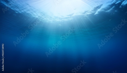 abstract image of tropical underwater dark blue deep ocean wide nature background with rays of sunlight and blue sky in background