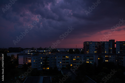 night view of the city. The sky over the city before rain and thunderstorm. The sunset illuminates the dark clouds.