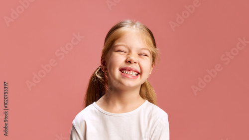 Young girl smiles brightly, scrunching her nose in delight. Her joyful expression reflects pure happiness and innocence of childhood. Concept of happiness, curiosity, positive vibes. Ad