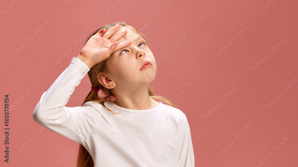 Little girl raises her hand to her forehead as if checking for sun or ...