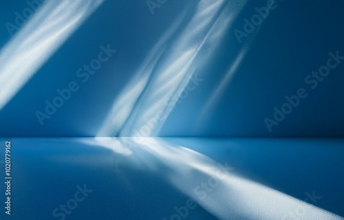 A blue wall with a horizontal line across the bottom, sunlight streams through a window casting long shadows on the wall and floor.