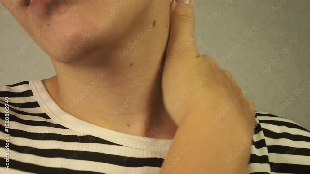 A man massages his neck. A man massages his neck.