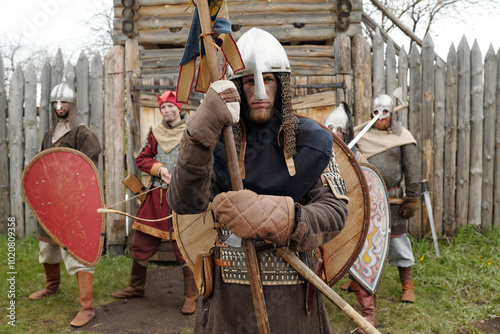 Fotografie Group of medieval armored warriors standing in front of wooden fort entrance, ho
