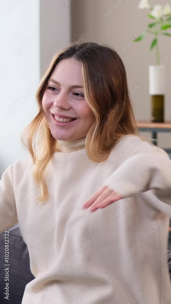 Smiley young adult Caucasian woman in good mood dancing to music at home living room. Concept of an entertainment and fun. Vertical video. Smiley young adult Caucasian woman in good mood dancing to music at home living room. Concept of an entertainment and fun. Vertical video.