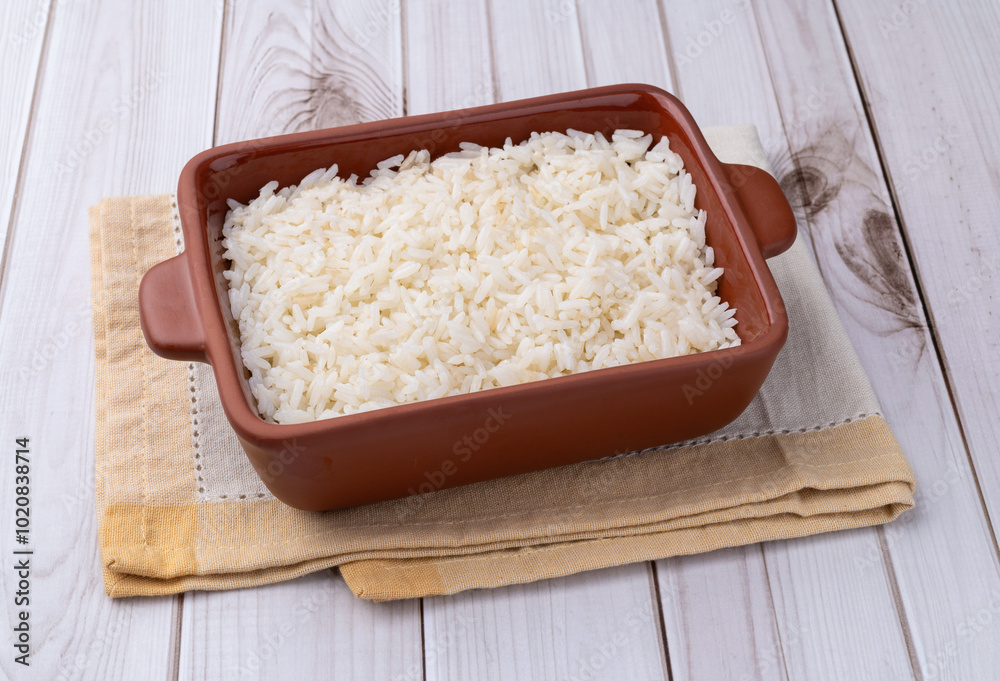 Cooked white rice in a plate over wooden table Cooked white rice in a plate over wooden table