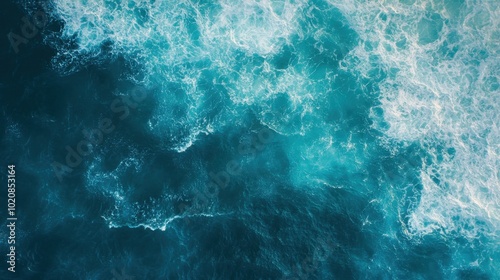 From above aerial view of turquoise ocean water with splashes and foam for abstract natural background and texture.