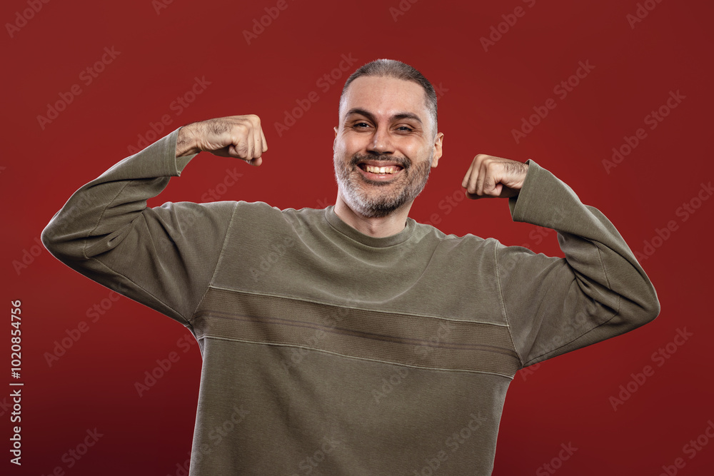 Naklejka premium man smiling with both arms flexed