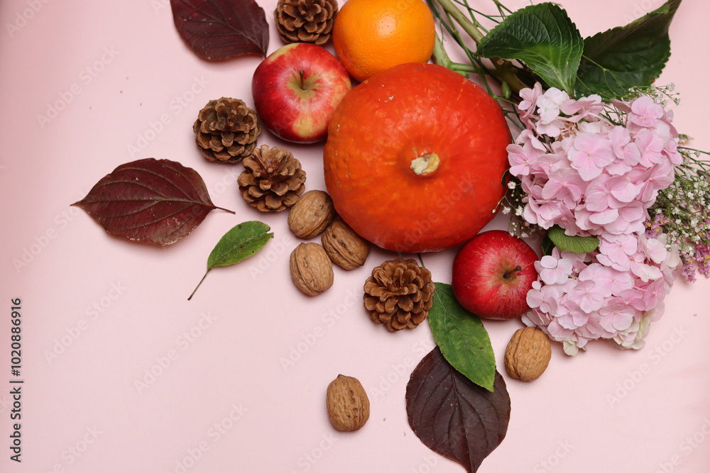Autumn composition with seasonal fruit and vegetables. Pumpkins, apples, nuts and flowers on pink background with space for text. Eating fresh concept. 