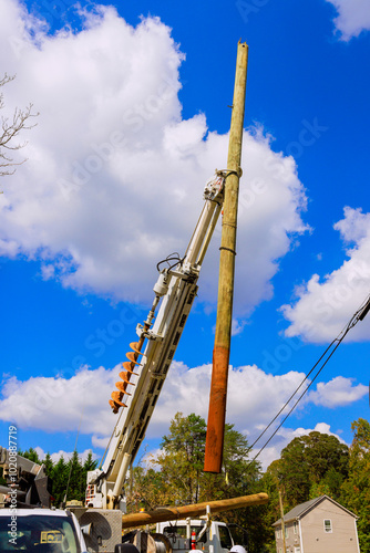 Foto As result of severe hurricane, damaged electric pole power lines are being repla