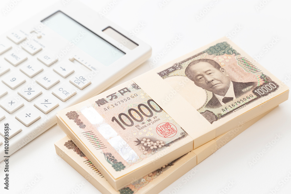 白背景に一万円の札束と電卓 白背景に一万円の札束と電卓