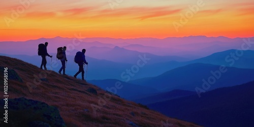 Group of people hiking up a hill at sunset, with warm light and shadows