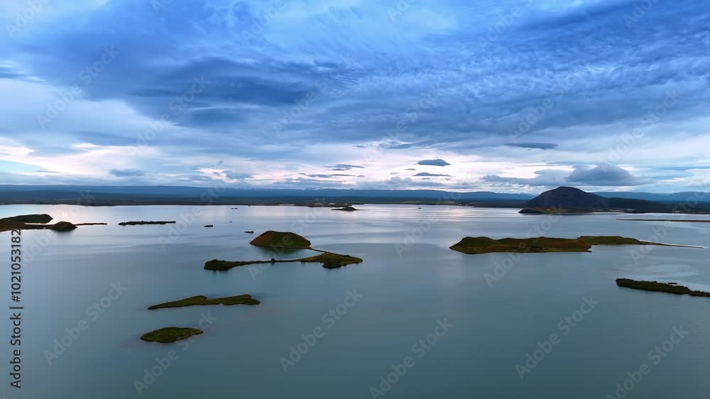 Waterscape with peaceful surface and little rock islands sticking out of water. Dramatic cloudscape covering the sky. Scenic view of Iceland. Waterscape with peaceful surface and little rock islands sticking out of water. Dramatic cloudscape covering the sky. Scenic view of Iceland.