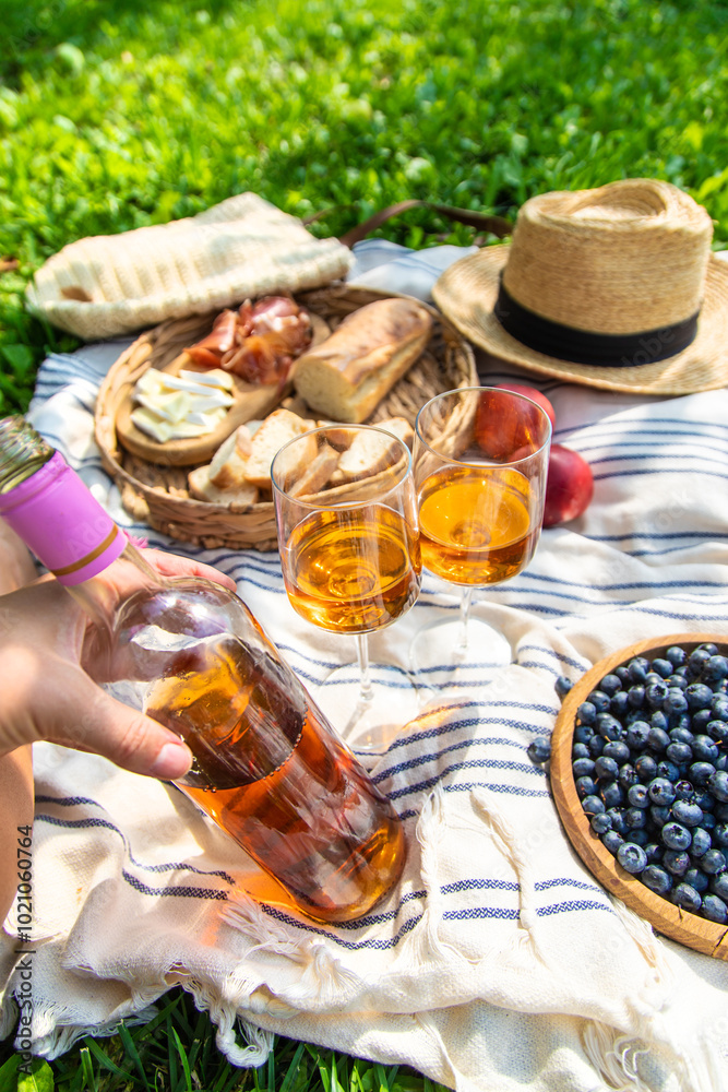 Fototapeta premium Wine in hands of woman at picnic. Selective focus.