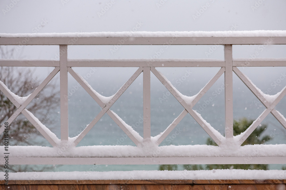 snow-covered wooden fence with sea view snow-covered wooden fence with sea view