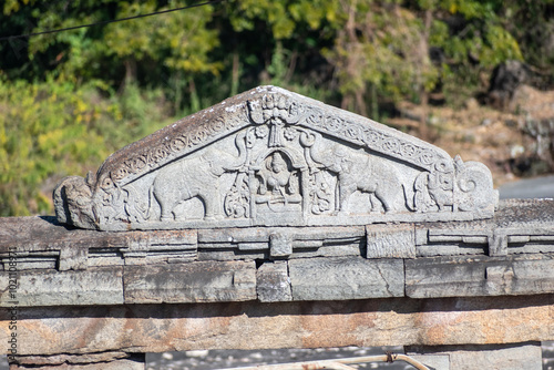 Ancient carvings of decorative elephants worshipping a deity on the roof of an ancient temple in Karnataka in South India. photo