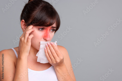 Woman with tissue suffering from sinusitis on grey background. Space for text