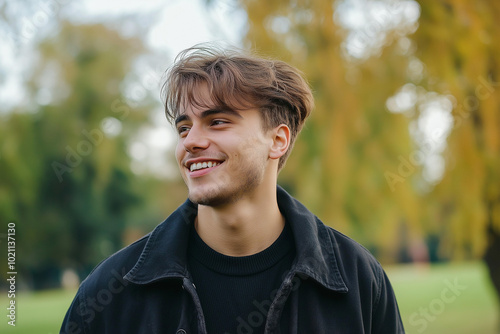 Relaxed and Active Young Man Enjoying a Walk in the Park, Smiling and Looking Away