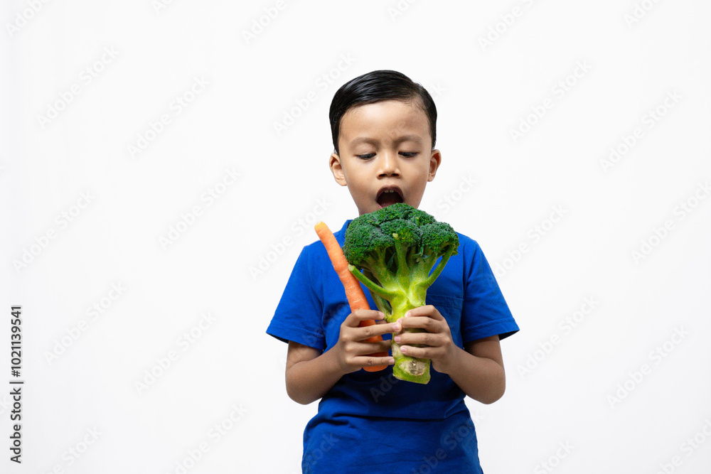 Cute Indonesian boy singing using broccoli vegetables, healthy lifestyle concept, isolated white background.
Cute Indonesian boy singing using broccoli vegetables, healthy lifestyle concept, isolated white background.