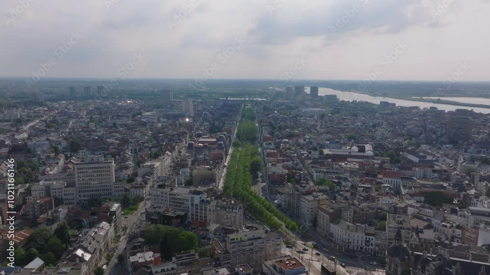 Aerial views showcase Antwerp's city center, gradually revealing the Scheldt River in the background. The scene captures a vibrant urban landscape under a sunny sky Aerial views showcase Antwerp's city center, gradually revealing the Scheldt River in the background. The scene captures a vibrant urban landscape under a sunny sky
