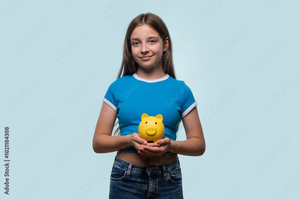 Girl smiling while holding yellow piggy bank Girl smiling while holding yellow piggy bank
