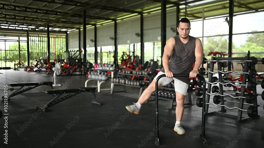 An Asian Man Stretching Before a Workout in the Gym, Focused on Fitness and Healthy Living, Preparing for Weightlifting and Strength Training, Representing a Passion for Health and Wellness