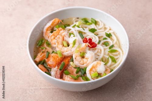 Фотография Asian dish with broth, noodles, tiger shrimp, fish and green onions