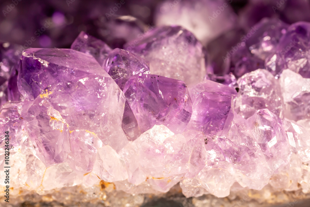 Amethyst purple crystals. Gems. Mineral crystals in the natural environment. Texture of precious and semiprecious stones. Seamless background with copy space colored shiny surface of precious stones. Amethyst purple crystals. Gems. Mineral crystals in the natural environment. Texture of precious and semiprecious stones. Seamless background with copy space colored shiny surface of precious stones.