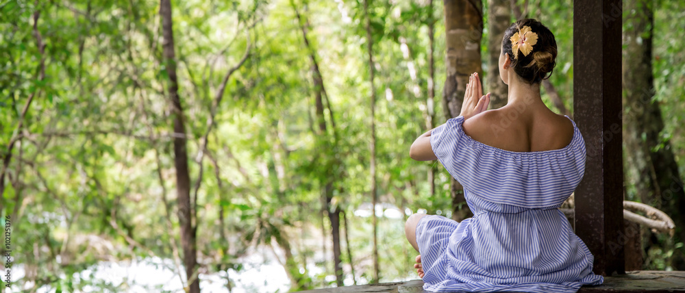 The girl meditates in nature. View from the back.