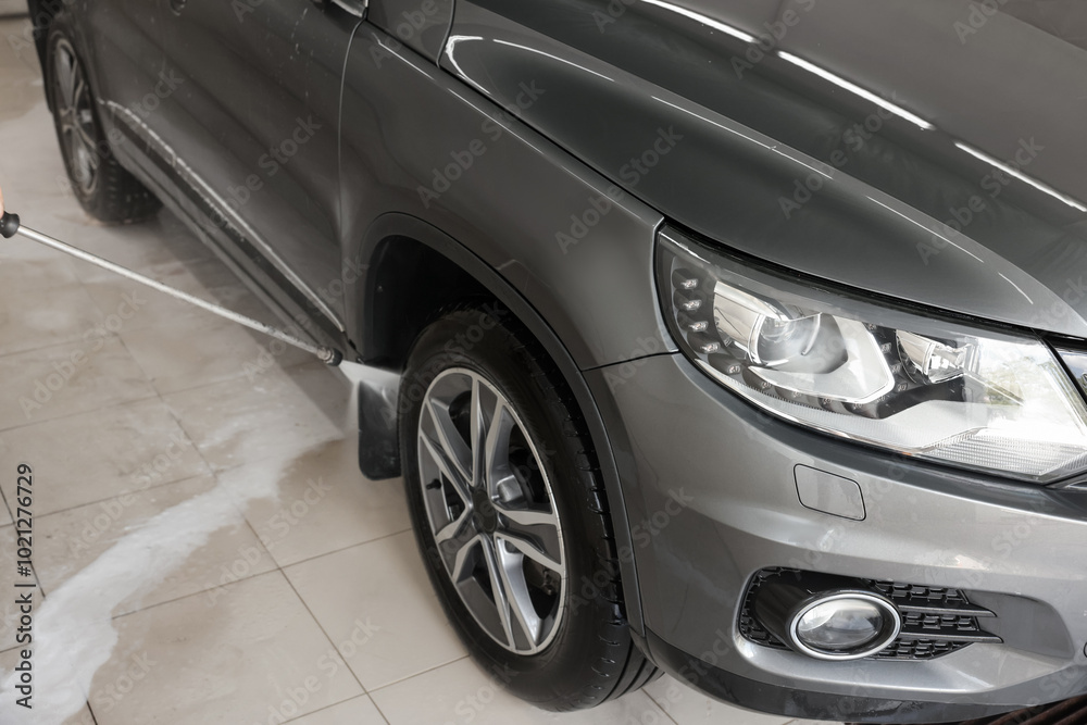 Washing auto with high pressure water jet at car wash, closeup Washing auto with high pressure water jet at car wash, closeup